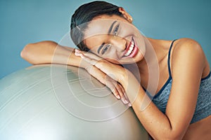 Motivate yourself or no one will. a sporty young woman leaning against a pilates ball.