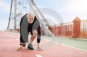 Motivated athletic senior sportsman running by walking bridge