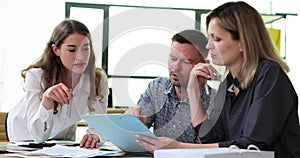Motivated business people are brainstorming together on paperwork in a team meeting in office