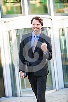 Motivated businessman punching the air