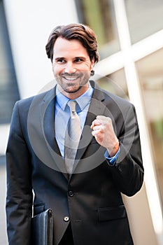 Motivated businessman punching the air