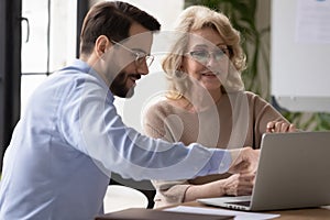 Motivated colleagues work on laptop in office together