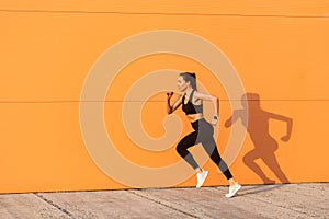 Motivated confident fit woman athlete in tight sportswear, black pants and top, starting to run, jogging outdoor