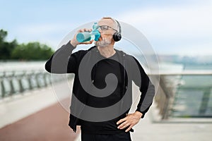 Motivated elderly sportsman have outdoor workout, drinking water