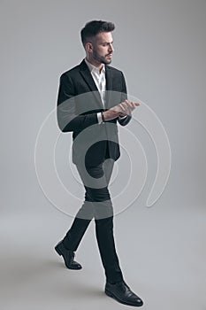 Motivated elegant man holding hands together, wearing suit