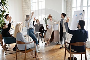 Motivated employees raising hands, asking coach at training.