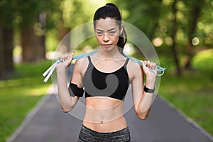 Motivated Fit Asian Woman Posing With Skipping Rope Outdoors, Training In Park