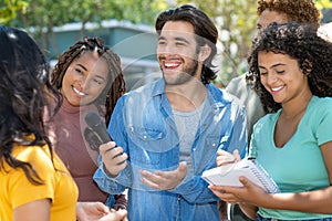 Motivated male journalist with group of reporters at interview