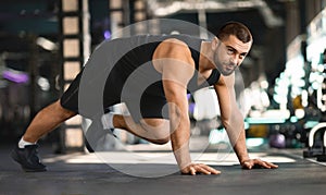 Motivated Muscular Man Making Running Plank Exercise While Training In Gym