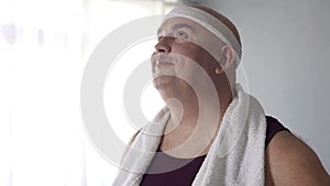 Motivated overweight man in sportswear imagining his future weight loss result