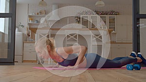 Motivated sporty fit mature woman exercising yoga cobra pose indoors