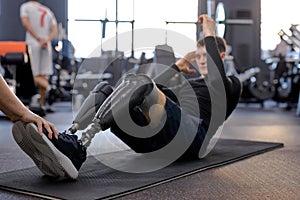 motivated strong man with legs prosthesis doing abdominal crunches