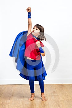 Motivated super hero kid showing strength and imagination, reaching success