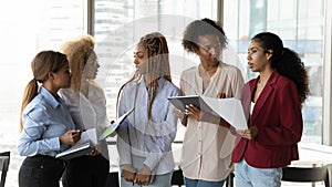 Motivated young african american teammates communicating at workplace.