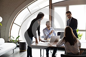 Motivated young mixed race business people holding negotiations meeting. photo