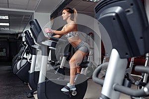 Motivated young woman doing cardio on the xtrainer machine in gym. Fat burn. Health concept. Weight loss.