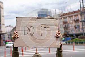 Motivation from a guy with sign. Do it. Banner message on street.