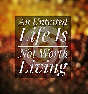 Motivation quote - An Untested Life Is Not Worth Living. Blurry background embers