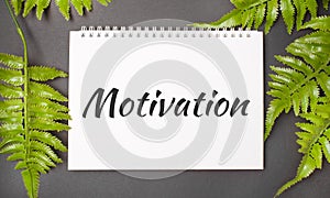MOTIVATION text with real leaves tropical jungle background.flat lay design