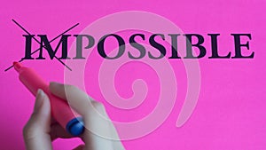 Motivational inscription impossible is possible on a pink background. Coaching, trainings, affirmations. Woman hand writes the photo
