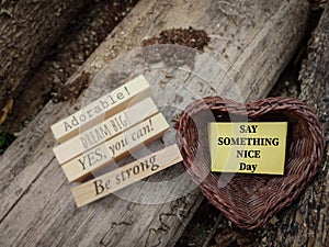 motivational and inspirational celebration concept - SAY SOMETHING NICE day text on notepaper inside heart shaped basket