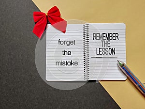 Motivational and inspirational quote of forget the mistake, remember the lesson written on notepad