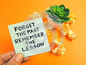 Motivational and inspirational quote - forget the past, remember the lesson handwritten on sticky note. Positive thinking,