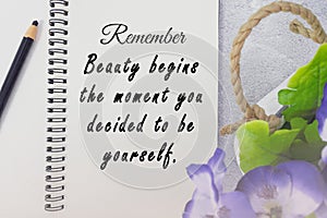 Motivational and inspirational quote on notepad with potted plant background.