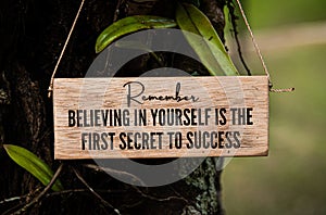 Motivational and inspirational quote text on wooden block - Believing in yourself is the first secret to success. With