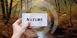 Motivational inspiring hand holding word card nature in woods