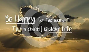 Motivational quote `Be happy for this moment. This moment is your life.` on a background with cloud and rays of sunlight from behi