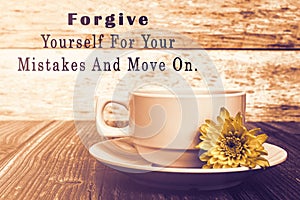 Motivational quote with coffee cup and flowers on wooden table.