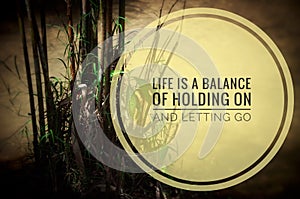 Motivational quote - Life a balance of holding on and letting go. With Bamboo and water background.