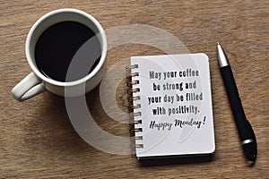 Motivational quote on notepad with coffee cup and pen on wooden desk