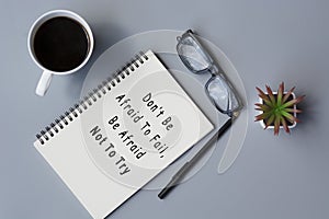 Motivational quote on notepad with cup of coffee and reading glasses