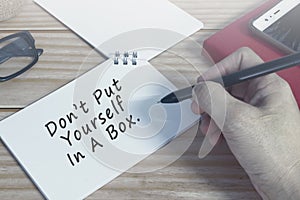 Motivational quote on notepad. Do not put yourself in a box.