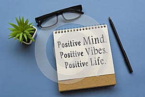 Motivational quote on notepad - Positive Mind, Positive Vibes, Positive Life.