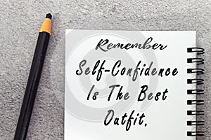 Motivational quote on notepad - Remember self confidence is the best outfit.