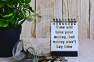 Motivational quote on paper stand and blurred glass jars with multicurrency coins