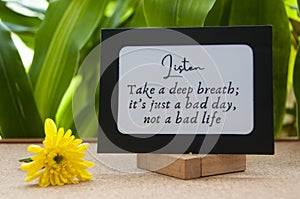 Motivational quote text on notepad - Take a deep breath, it's just a bad day, not a bad life.