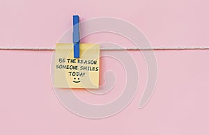 Motivational quotes - Be the reason someone smiles today. Text on hanging paper note