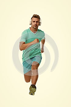 Motivational song. Man sportsman running with headphones. Runner handsome strong guy in motion isolated on white. Music