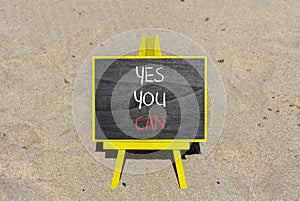 Motivational and Yes you can symbol. Concept words Yes you can on beautiful black chalk blackboard. Beautiful sand beach