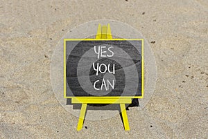 Motivational and Yes you can symbol. Concept words Yes you can on beautiful black chalk blackboard. Beautiful sand beach