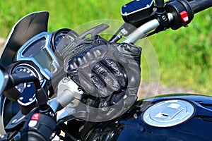 Moto gloves on the handlebars of motorcycle