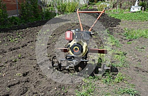 Moto plow or two-wheel tractor, walking tractor which can pull and power various farm implements such as a trailer, cultivator photo