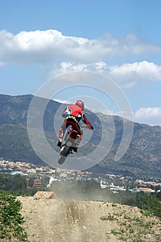 Moto X Motorbike jumping through the air on a hot sunny day with big blue sky