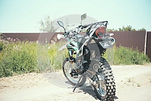 motocross bike stands on a sandy road