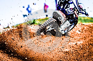 Motocross Biker Accelerating in a Curve With Flying Mud and Debris