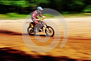 Motocross biker travelling fast in the sunshine